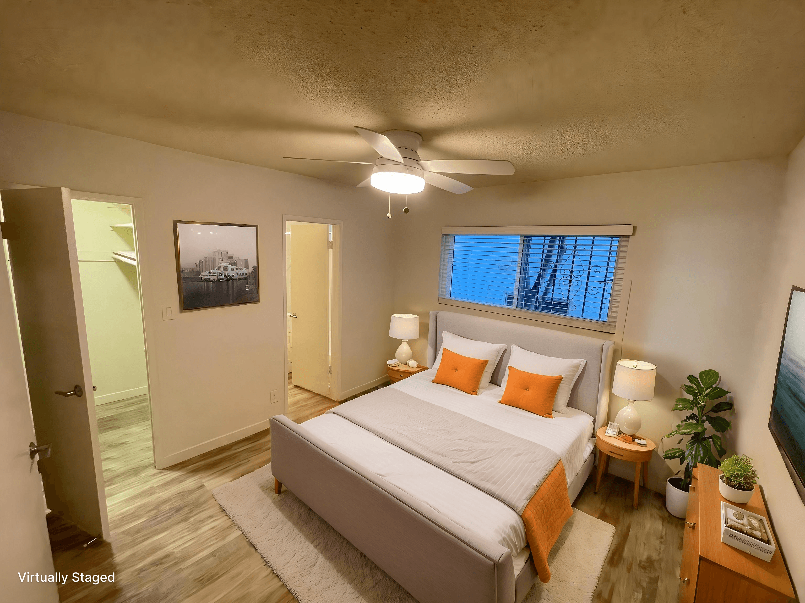 A bedroom with a bed, a ceiling fan, and a window.